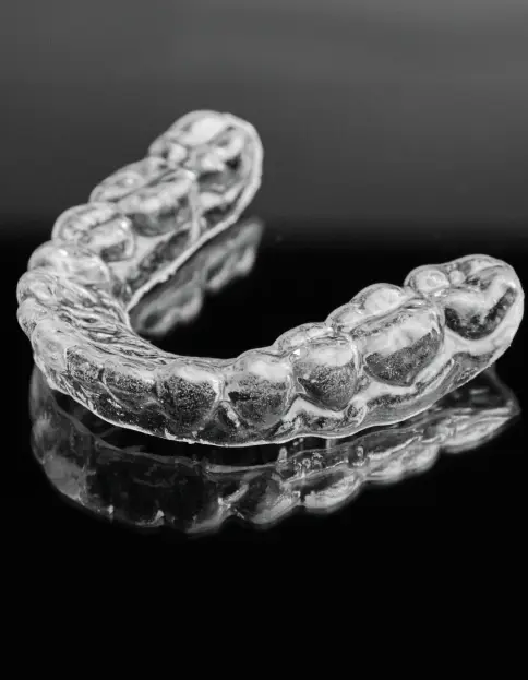 Clear dental aligner appliance displayed against dark background showing custom airway-focused design.