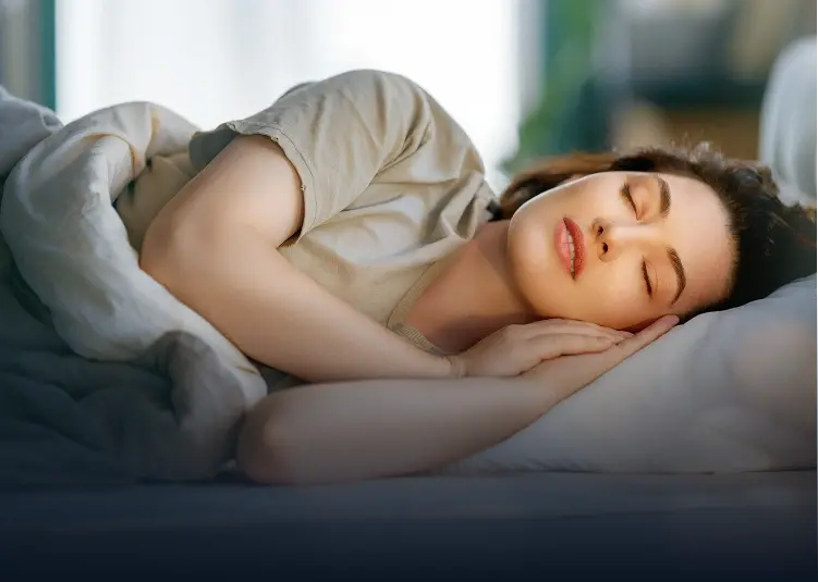 Woman sleeping peacefully on pillow, demonstrating restful sleep related to snoring and sleep apnea treatment.